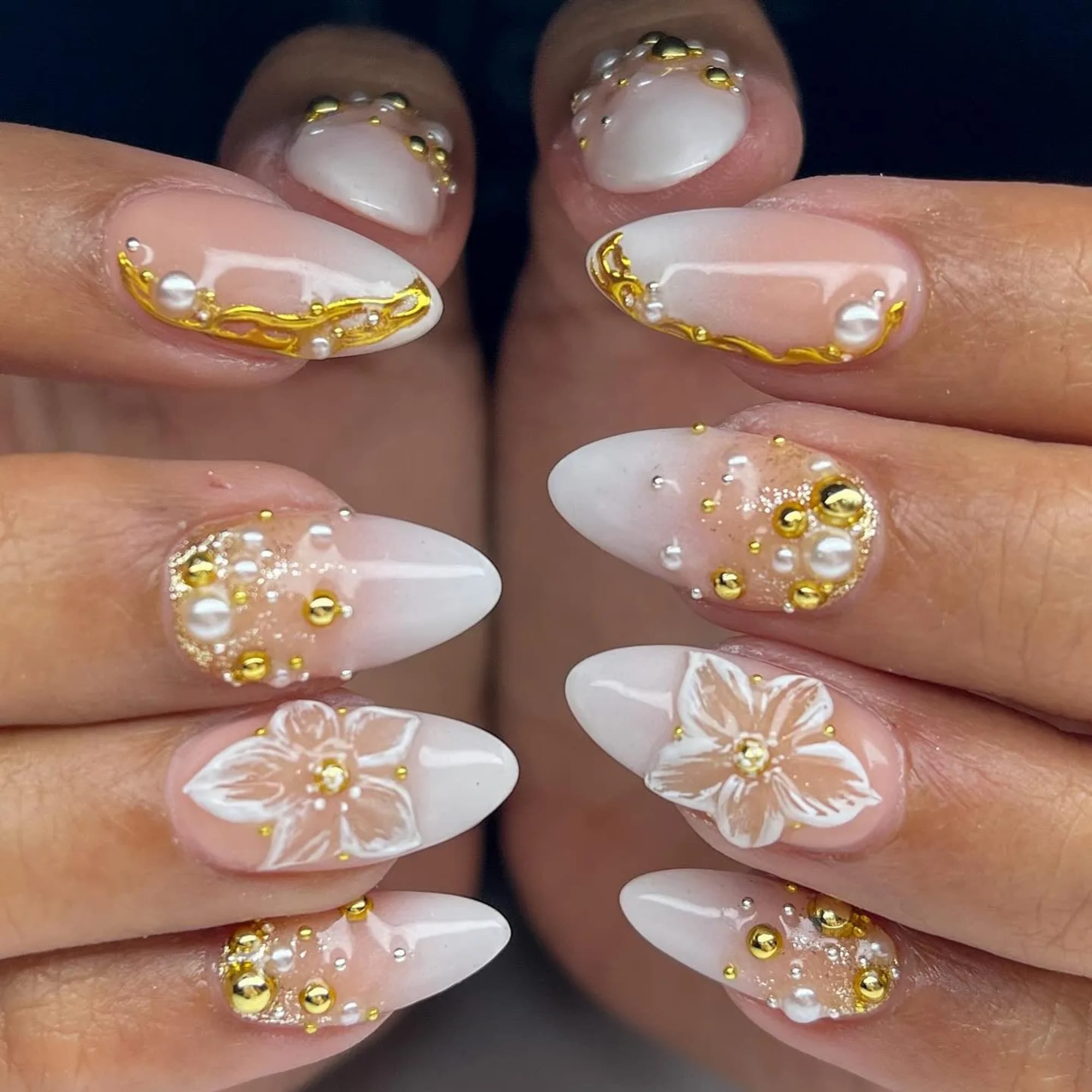White-tip almond nails with gold pearl and floral embellishments